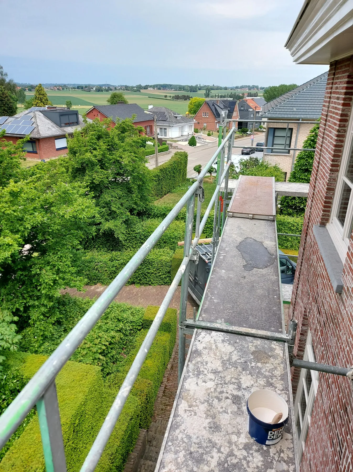 Schilder werkt aan buitenschrijnwerk op hoogte