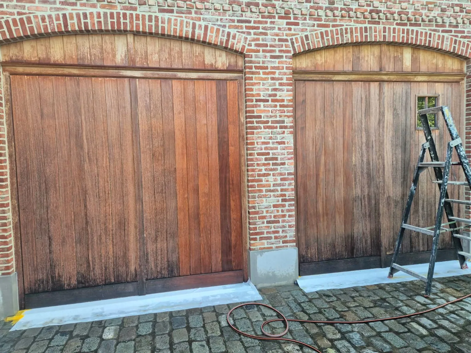 Houten garagepoorten voor de behandeling, uitgebleekt door zon en regen