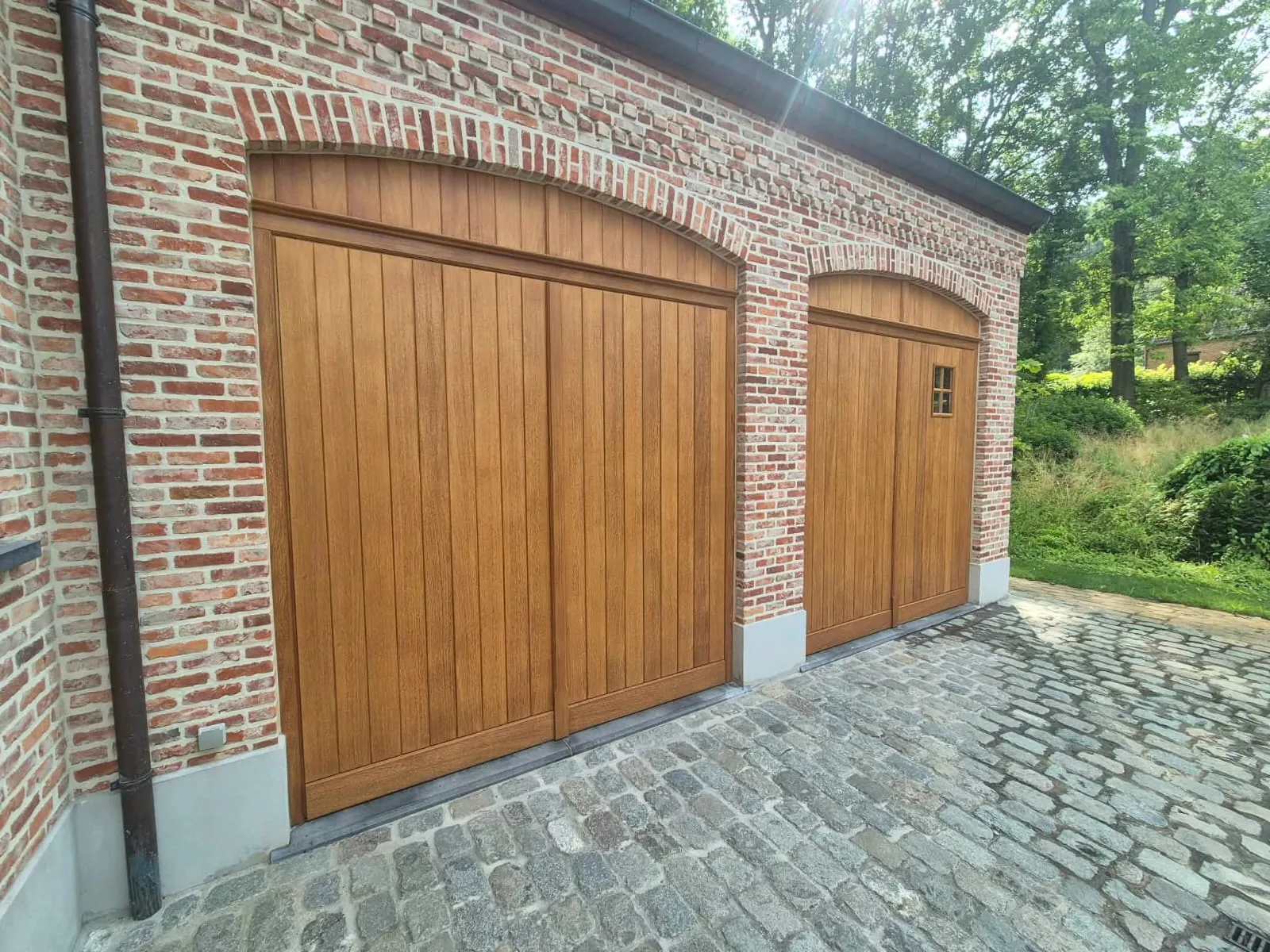 Dezelfde garagepoorten na het schuren en opnieuw afwerken van het hout